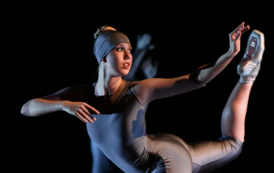 Dancer posing with on stage against black background